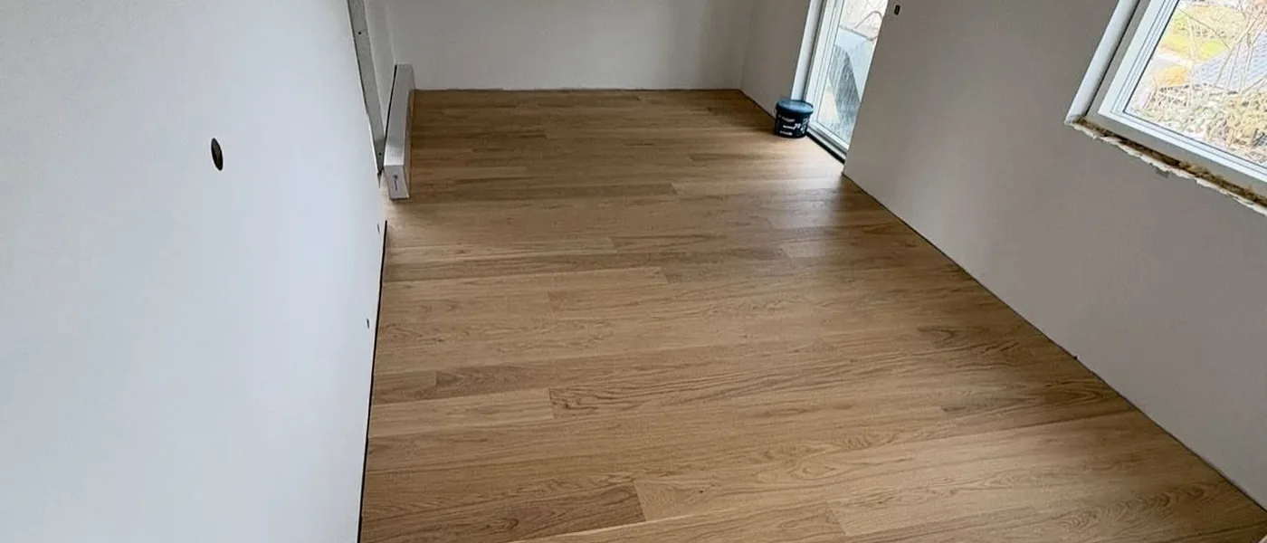 Nyt plankegulv færdiglagt i et lyst værelse